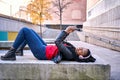 Portrait of a smiling African-American woman with a cell phone is chatting or listening to music on the streets of the city. The Royalty Free Stock Photo