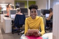 Portrait of smiling african american young businesswoman sitting with digital tablet at office Royalty Free Stock Photo