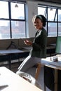 Portrait of smiling african american young businesswoman with smart phone in office Royalty Free Stock Photo