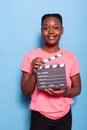 Portrait of smiling african american young woman holding filmography clapboard Royalty Free Stock Photo