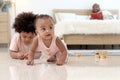 Portrait of smiling African cute toddle baby infant kid crawling on floor with blurred background of curly hair brother boy play Royalty Free Stock Photo