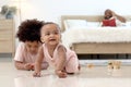 Portrait of smiling African cute toddle baby infant kid crawling on floor with blurred background of curly hair brother boy play Royalty Free Stock Photo