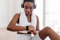 Sporty African woman checking fitness tracker during workout break Royalty Free Stock Photo