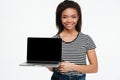 Portrait of a smiling african woman showing blank screen laptop Royalty Free Stock Photo