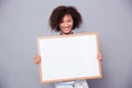 Portrait of a smiling afro american woman holding blank board Royalty Free Stock Photo