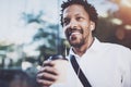 Portrait of Smiling American African man in headphone walking at sunny streets with coffee in take away cup and enjoying Royalty Free Stock Photo