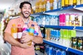 Portrait of man customer who is standing with drinks in supermarket. Royalty Free Stock Photo