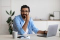Portrait Of Smiling Arab Freelancer Guy Sitting At Desk In Home Office Royalty Free Stock Photo