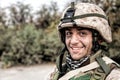 Portrait of smiling army soldier in ragged helmet