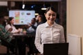 Portrait of smiling asian business employee holding laptop in startup office working overtime Royalty Free Stock Photo