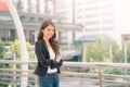 Portrait of a smiling asian businesswoman standing with arms folded on blurred city background. Business concept Royalty Free Stock Photo