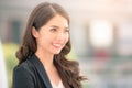 Portrait of a smiling asian businesswoman standing with arms folded on blurred city background. Business concept Royalty Free Stock Photo