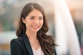 Portrait of a smiling asian businesswoman standing with arms folded on blurred city background. Business concept Royalty Free Stock Photo