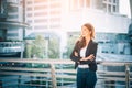 Portrait of a smiling asian businesswoman standing with arms folded on blurred city background. Business concept Royalty Free Stock Photo