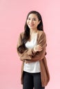 Portrait of a smiling asian businesswoman standing with arms folded and looking at camera isolated over pink background Royalty Free Stock Photo