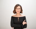 Portrait of a smiling asian businesswoman standing with arms folded and looking at camera isolated over white background Royalty Free Stock Photo