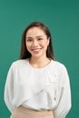 Portrait of a smiling asian businesswoman standing  looking at camera isolated over turquoise background Royalty Free Stock Photo