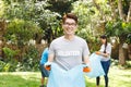 ortrait of smiling asian father, collecting rubbish in the countryside with son and daughter