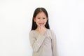 Portrait of smiling Asian little child girl with broken tooth and sucking finger in his mouth isolated on white background Royalty Free Stock Photo