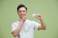 Portrait smiling Asian man in white T-shirt holding skin care Royalty Free Stock Photo