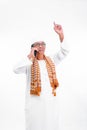 Portrait of smiling asian muslim old man wear white clothes talking on a smartphone and raise one arm isolated over white Royalty Free Stock Photo