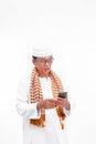 Portrait of smiling asian muslim old man wear white clothes using smartphone isolated over white Royalty Free Stock Photo