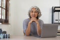 Portrait of smiling asian senior mature middle aged businesswoman using laptop working and web surfing on desk. Royalty Free Stock Photo