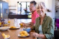 Portrait of smiling asian senior woman having breakfast with caucasian man at dining table Royalty Free Stock Photo