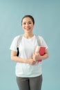 Portrait of a smiling asian student girl wearing backpack and holding books isolated over blue background Royalty Free Stock Photo