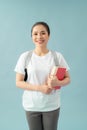 Portrait of a smiling asian student girl wearing backpack and holding books isolated over blue background Royalty Free Stock Photo