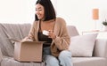 Happy asian woman unpacking parcel with beauty box Royalty Free Stock Photo