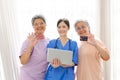 Portrait of smiling Asian women senior holding credit card and caregiver using laptop computer for online shopping and e-payment Royalty Free Stock Photo