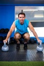 Portrait of smiling athlete with kettlebell in gym