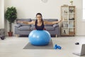 Portrait of a smiling athletic woman lying on a fitness ball with her arms outstretched. Royalty Free Stock Photo