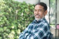 Portrait smiling attractive mature asian man retired with stylish short beard sitting outdoor Royalty Free Stock Photo
