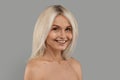 Smiling Attractive Mature Woman With Bare Shoulders Posing Over Grey Studio Background Royalty Free Stock Photo