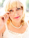 Portrait of smiling attractive senior lady in elegant garment with glasses. Royalty Free Stock Photo