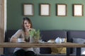 Portrait of smiling attractive woman in cafe looking at camera. Lonely woman sits in cafe