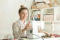 Portrait of smiling attractive woman at sewing machine