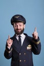 Portrait of smiling aviator pointing up with index fingers,