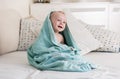 Portrait of cute smiling baby boy covered in big blue towel Royalty Free Stock Photo