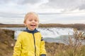 Portrait of a smiling baby boy near smaller waterfall around Gullfoss, Iceland Royalty Free Stock Photo