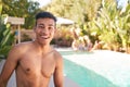Portrait Of Smiling Bare Chested Man Outdoors With Friends At Summer Pool Party
