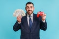 Portrait of smiling bearded businessman wearing dark official style suit holding in hands dollar