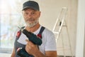 Portrait of smiling bearded worker in overalls with drill Royalty Free Stock Photo