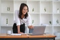 Portrait of smiling beautiful Asian businesswoman enjoy the idea sitting with laptop computer at office. Royalty Free Stock Photo