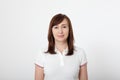 Portrait of smiling beautiful brunette woman in blank white t-shirt with copy space on white background. Mock up Royalty Free Stock Photo