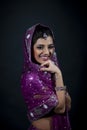 Portrait of smiling beautiful indian girl wearing traditional purple clothes Royalty Free Stock Photo