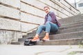 Portrait of smiling Beautiful modern young female teenager with extraordinary hairstyle color in checkered sitting on the old town