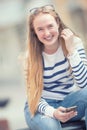 Portrait of a smiling beautiful teenage girl with dental braces. Young schoolgirl with school bag and mobile phone Royalty Free Stock Photo